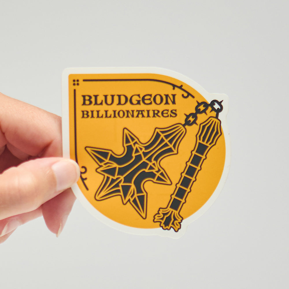 Hand holding a 'Bludgeon Billionaires' sticker with a yellow background and a flail weapon