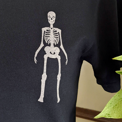 alt="Zoomed in view of a skeleton on ablack shirt"