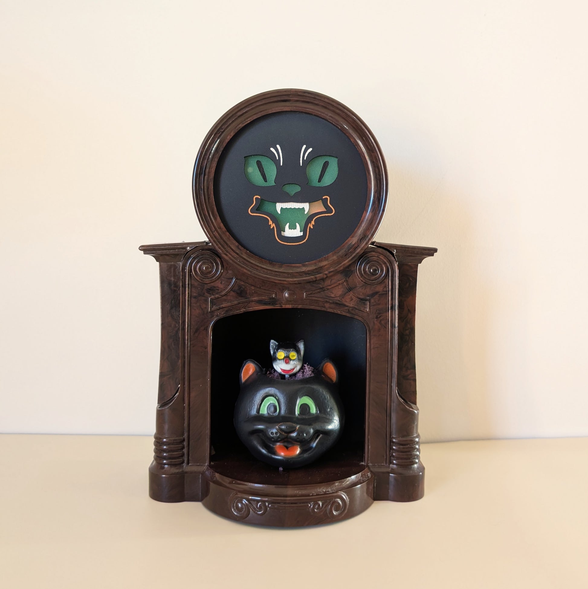 Decorative fireplace light with a vintage cat-themed design on a beige background