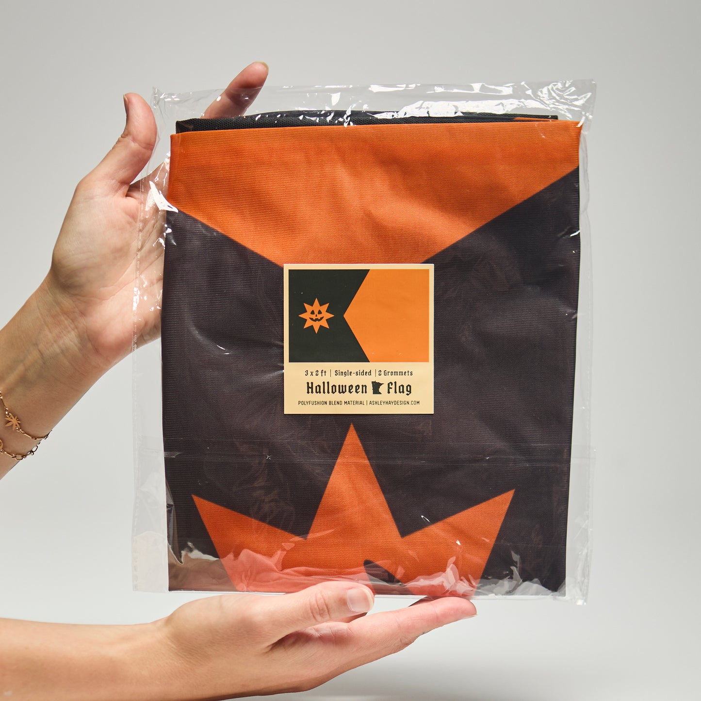 Halloween Minnesota flag in packaging held by a person against a plain background