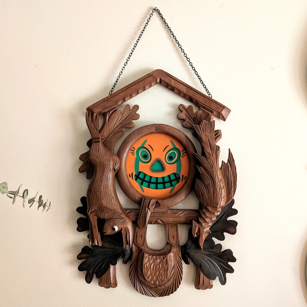 Cuckoo clock frame with a jack-o-lantern face.