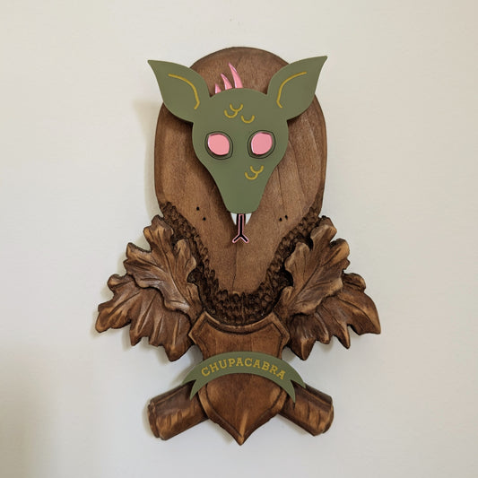 Vintage wood wall piece with an acrylic chupacabra head hanging on a white background.