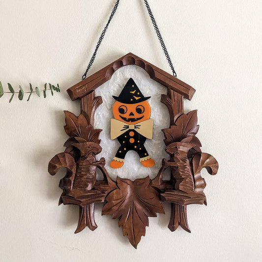 alt="Vintage squirrel cuckoo clock with spooky pumpkin person"