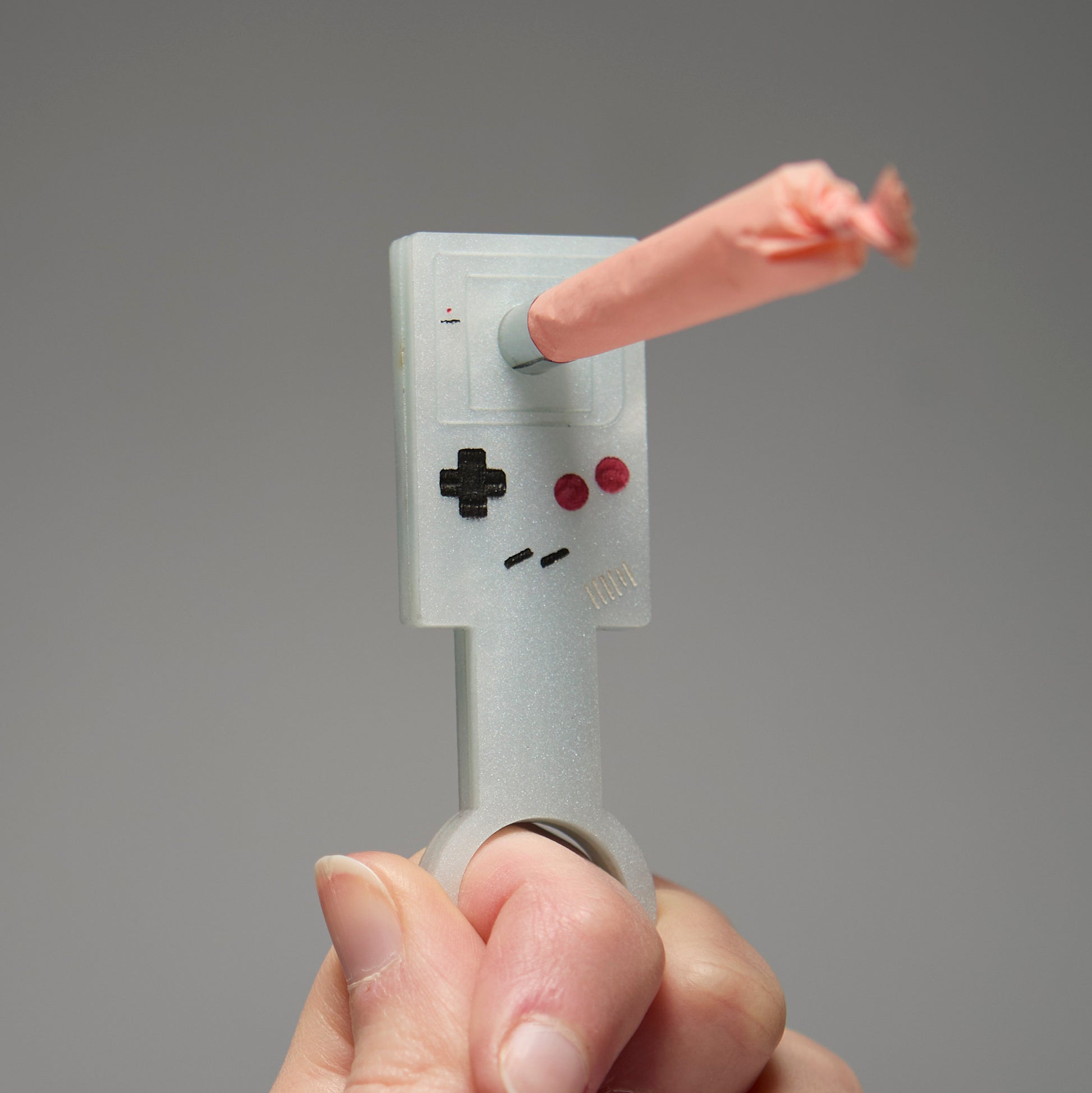 Handing holding a wand of a Gameboy with a pre-roll inserted into the middle. 