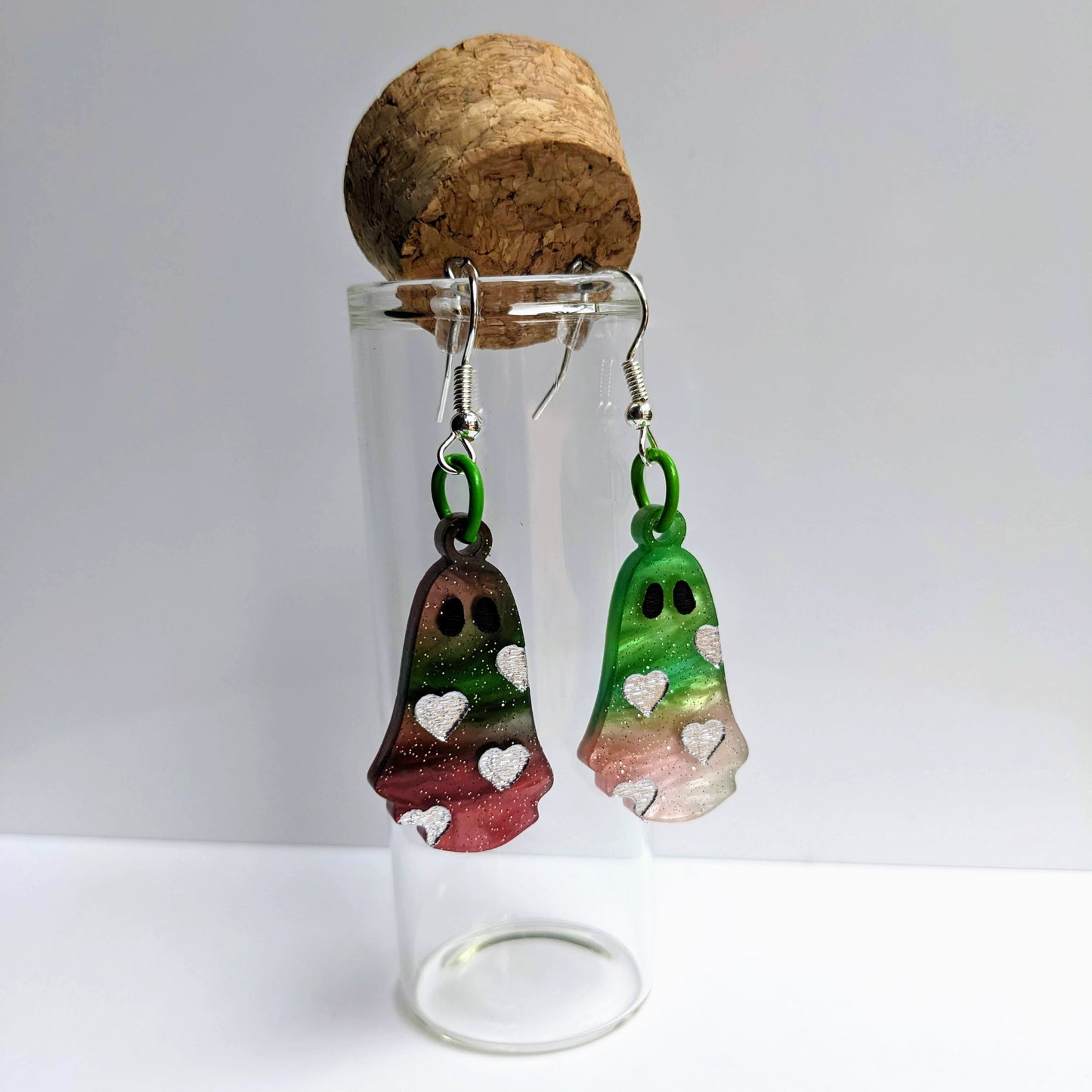 alt="Red and green glitter acrylic heart ghost earrings"