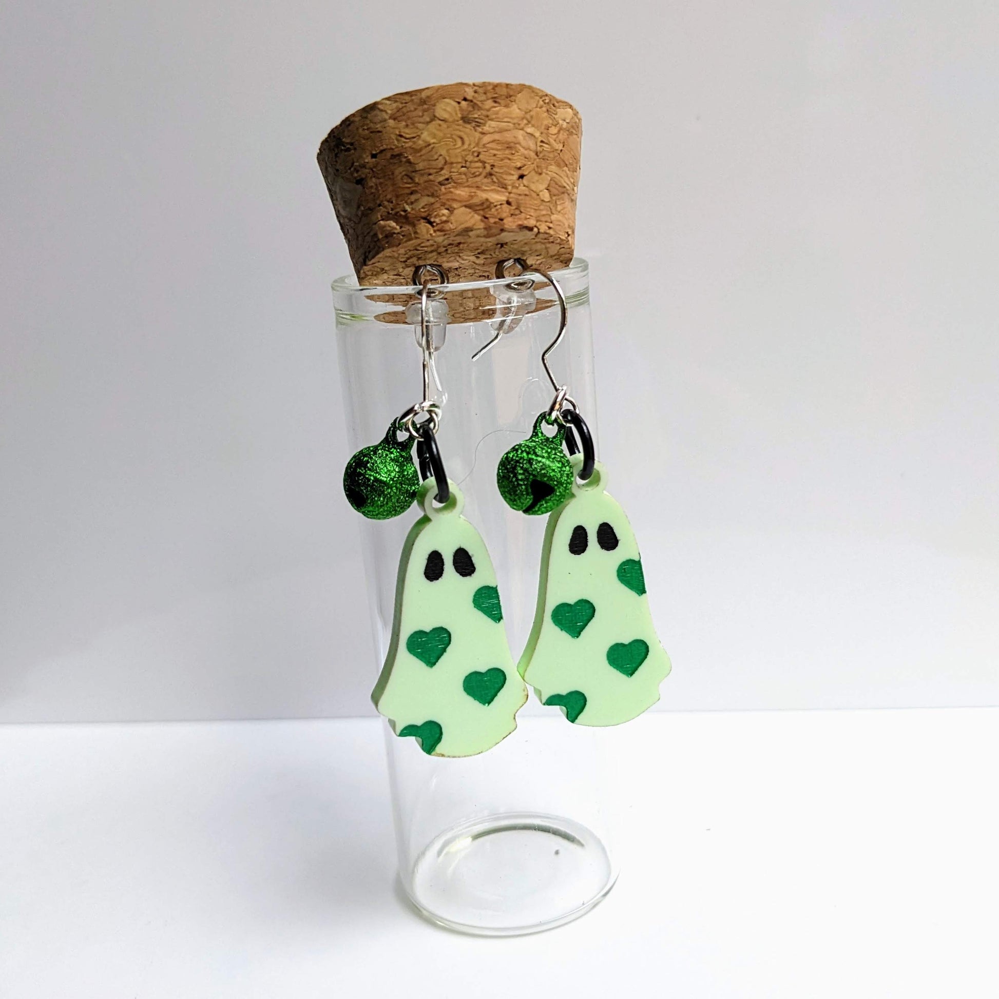 alt="Pastel green acrylic heart ghost earrings and bells"