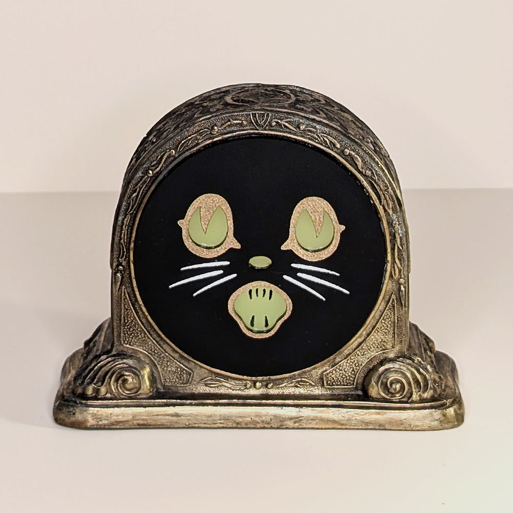 Repurposed vintage brass frame with a Biestle cat face