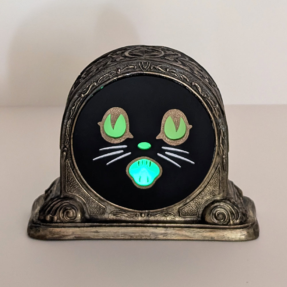 Repurposed vintage brass frame with a Biestle cat face lit up