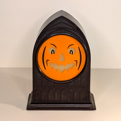 Vintage mantle clock of a Halloween face with an angry smirk