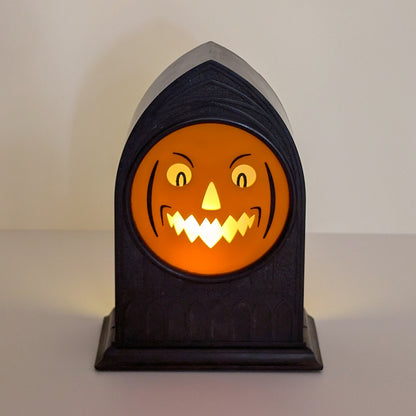 Vintage mantle clock of a Halloween face with an angry smirk lit up