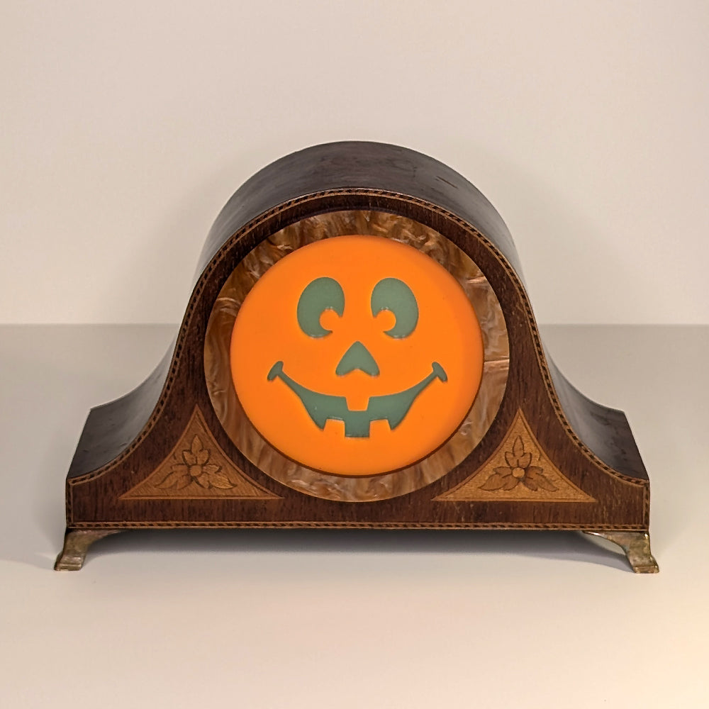 Vintage wood mantle clock with a jack-o-lantern smiling face