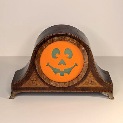 Vintage wood mantle clock with a jack-o-lantern smiling face