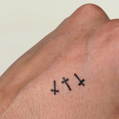 Black cross makeup stamps on a white hand