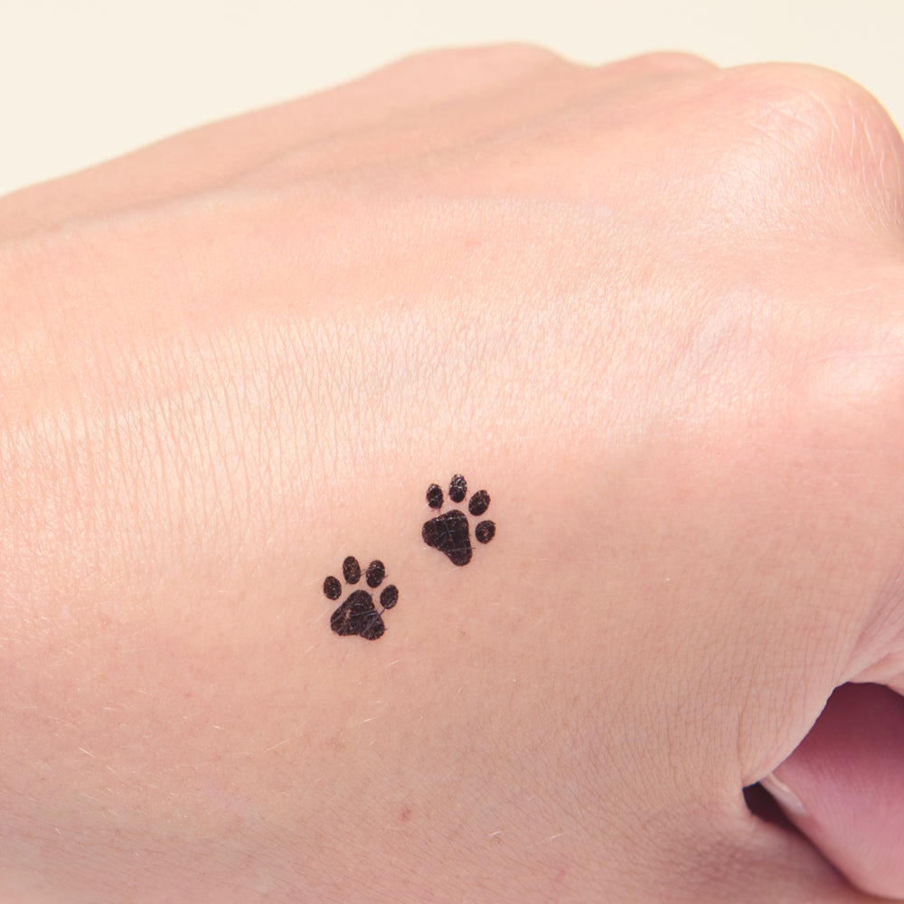 Black paw print makeup stamps on a light skin