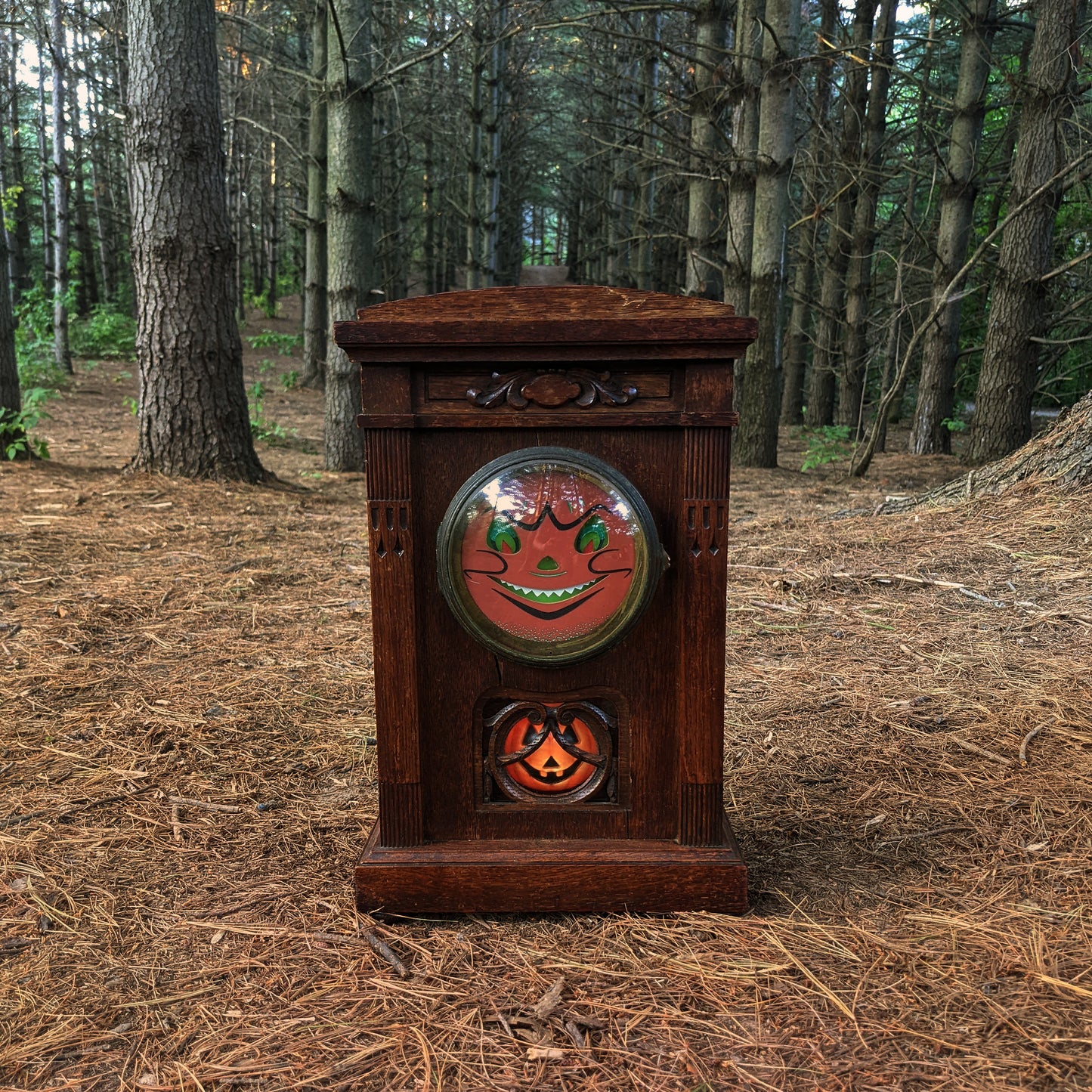 alt="Vintage mantle clock with Halloween face in woods"