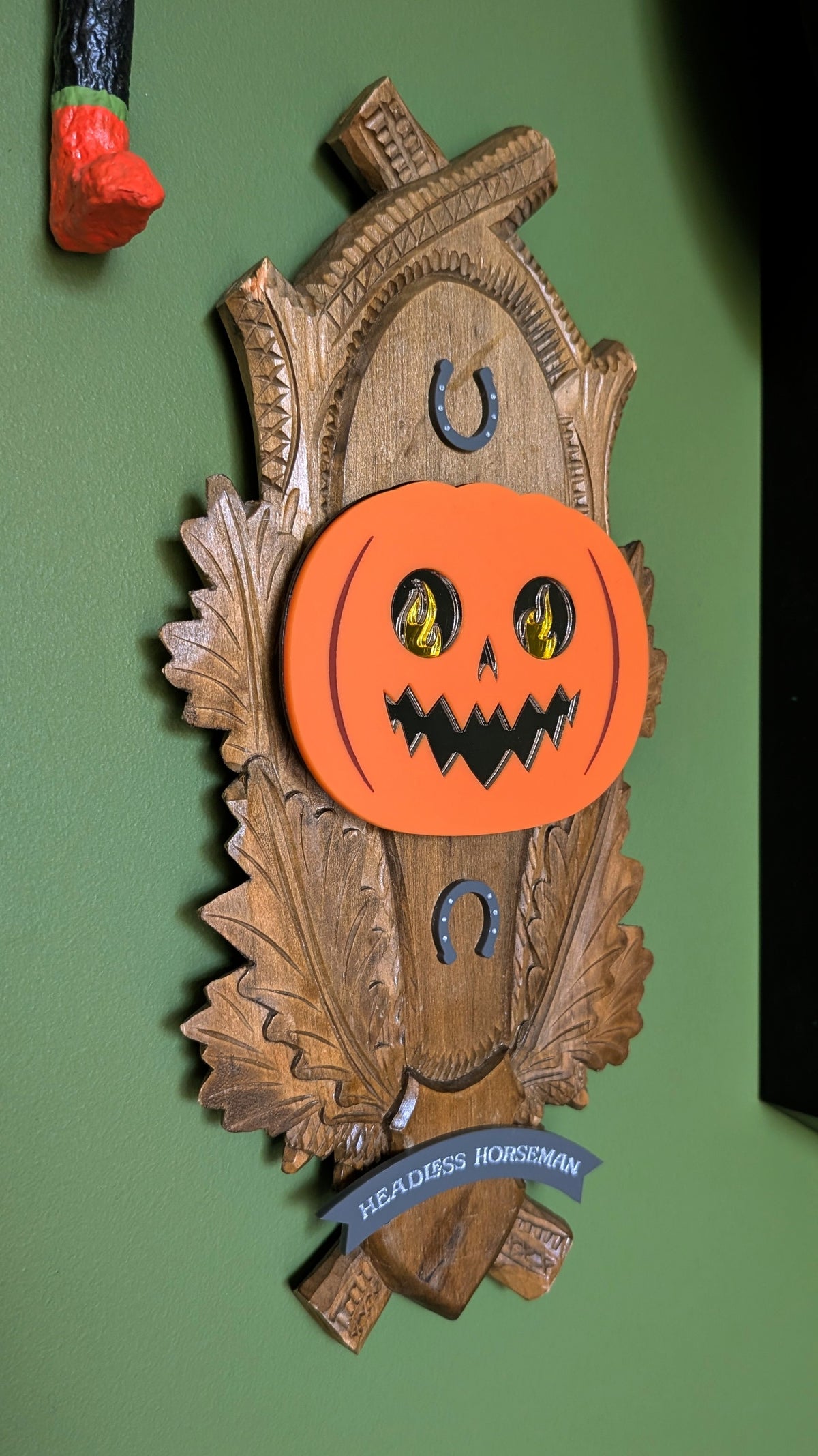 A vintage wooden carved wall plaque featuring an acrylic Headless Horseman and horseshoe accents. A gray banner reads 'HEADLESS HORSEMAN' at the bottom.