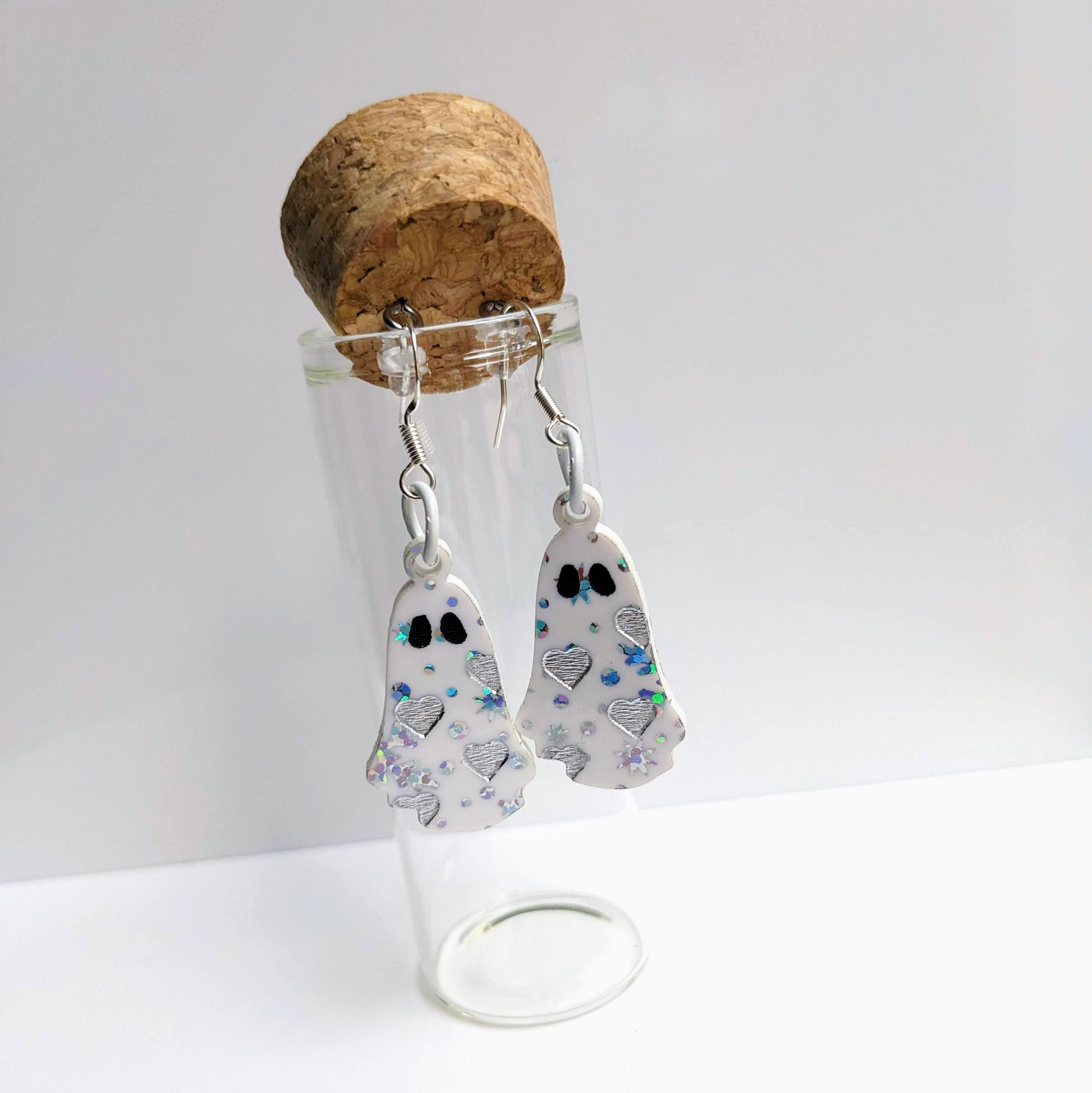 alt="Snow acrylic heart ghost earrings"