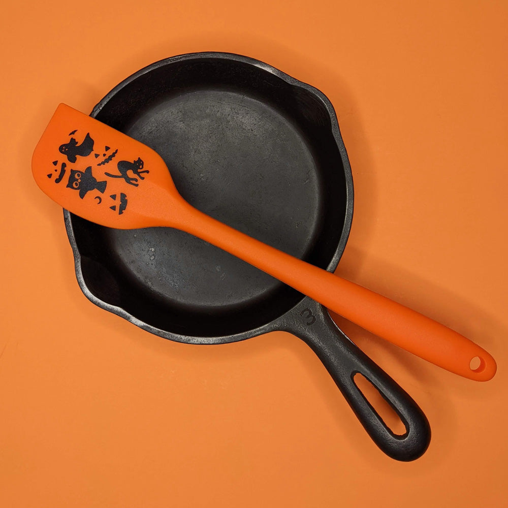 alt="Vintage Halloween orange spatula on pan"