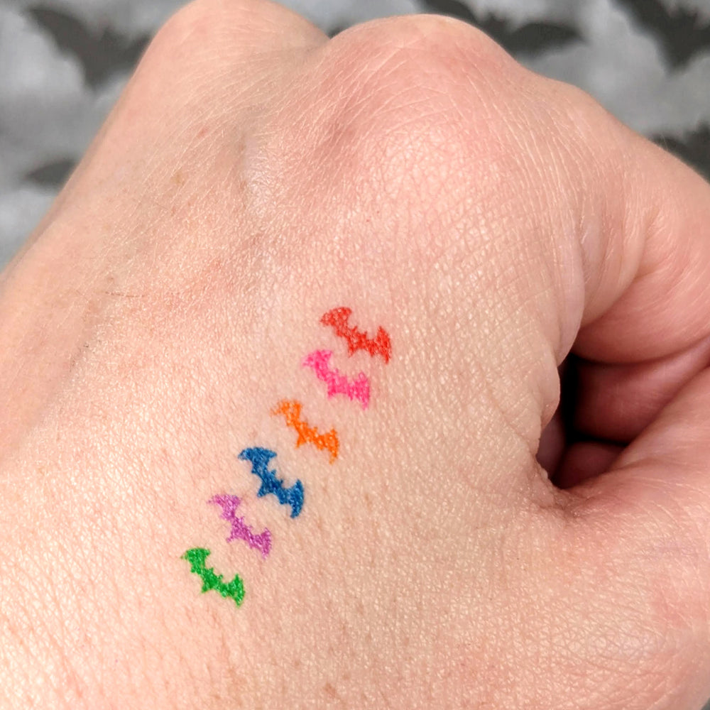 alt="rainbow bat makeup stamp on skin"